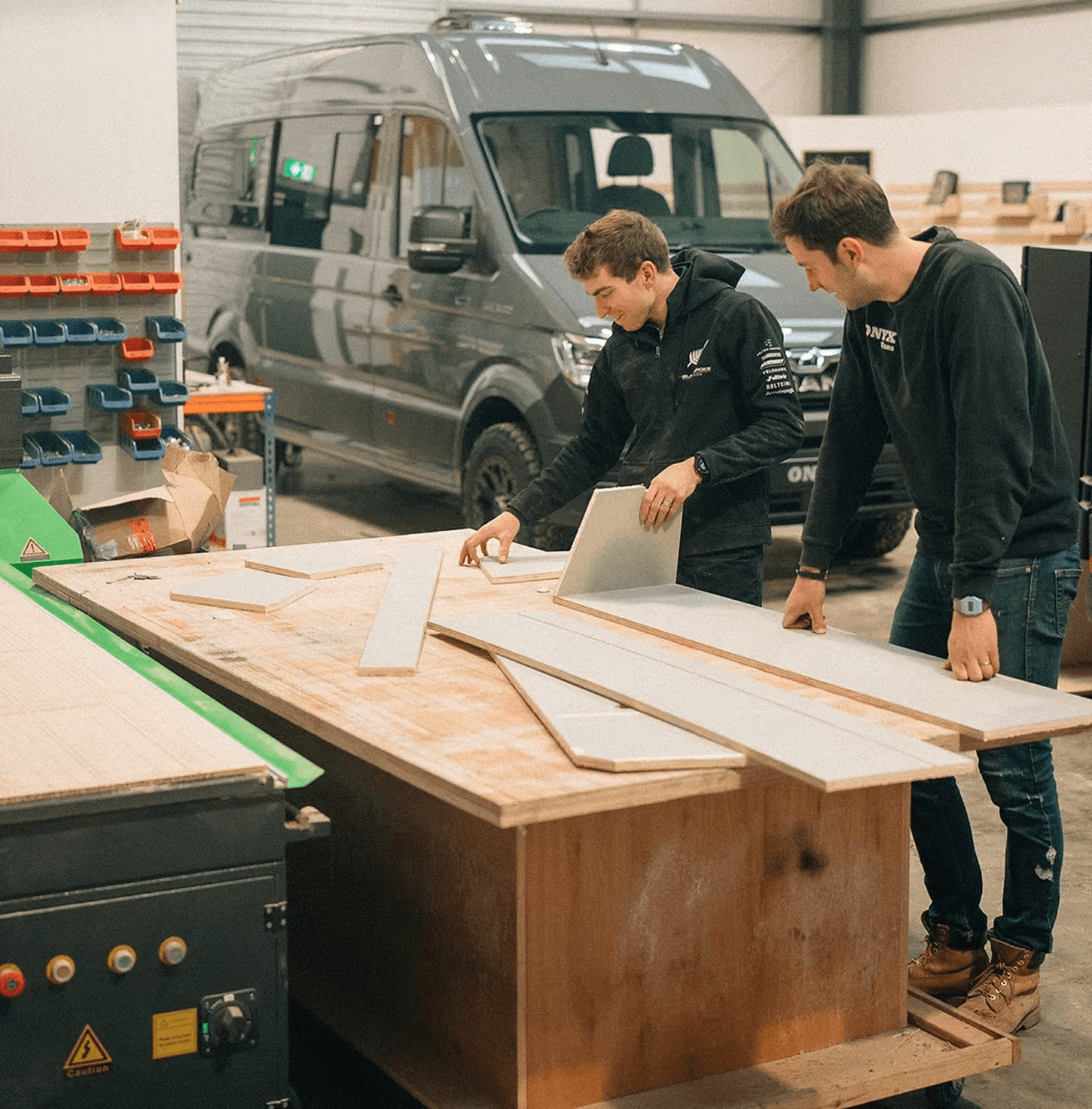 Campervan build professionals planning work in a workshop